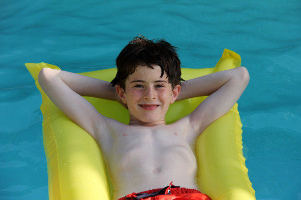 充气泳池床垫上的男孩图片下载