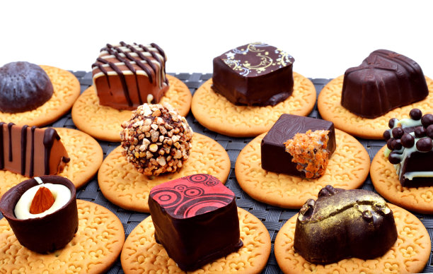巧克力糖果放在饼干上，甜点孤立在白色上图片下载