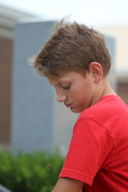 小男孩摆姿势时向下看的侧面照片图片下载