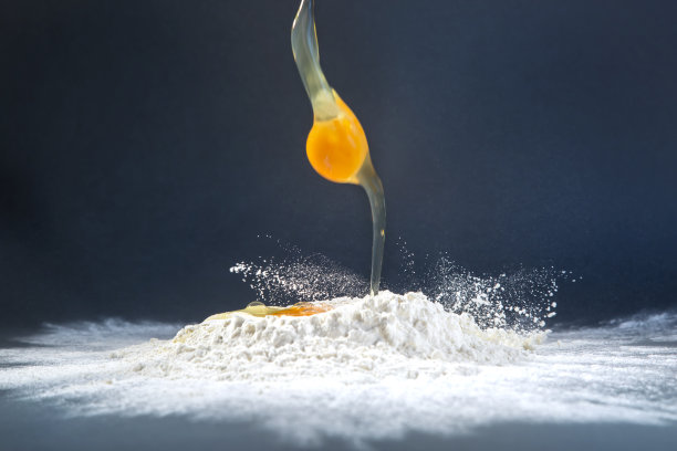 鸡蛋落在面粉上。图片下载