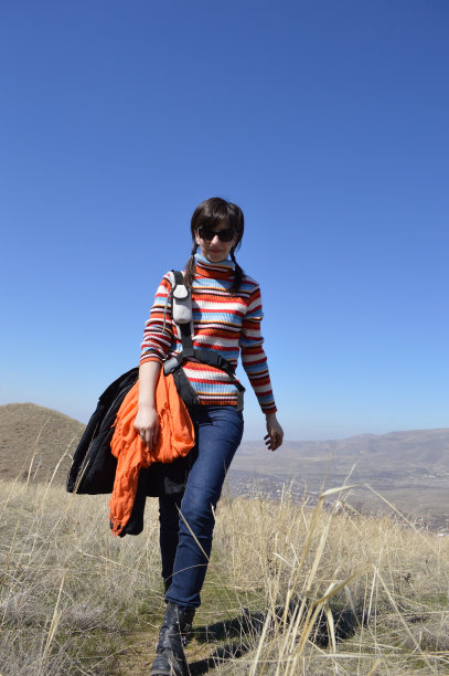 在山里徒步旅行的年轻妇女图片下载