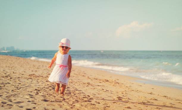 快乐可爱的小女孩在沙滩上跑步图片下载