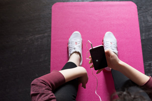 在健身房用智能手机的女人图片下载