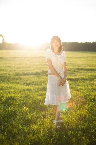 年轻女子站在田野上图片下载