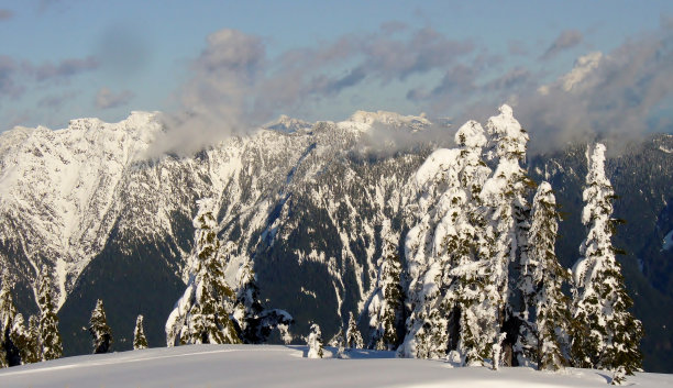 白雪覆盖着树木和山脉，还有美丽的小云朵图片下载