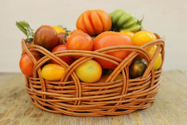 木桌上放着装满新鲜番茄的篮子图片下载