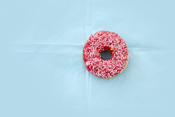 粉色的甜甜圈，蓝色的背景。图片下载