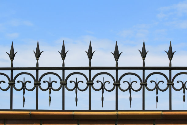 天空背景上的金属锻造栅栏图片下载