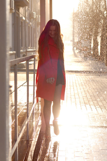 那个穿红色雨衣的女人沿街走着图片下载