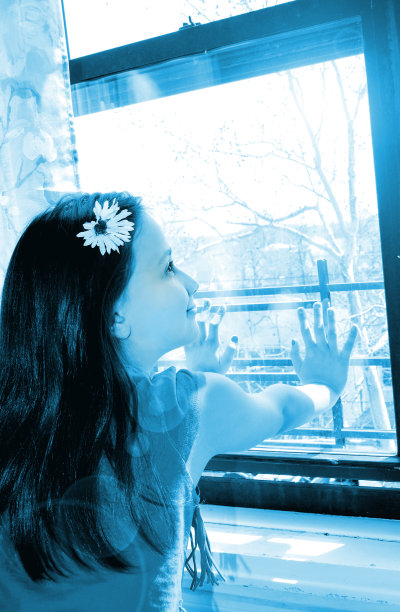 漂亮的年轻女孩向窗外看图片下载