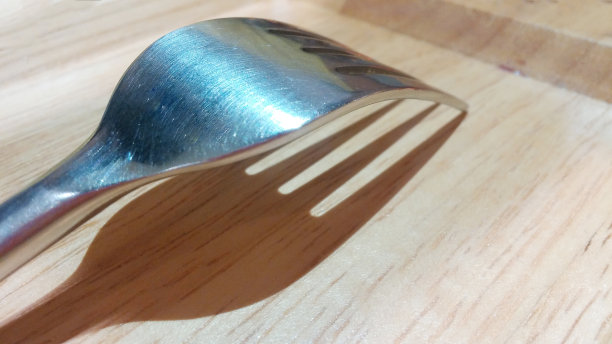 木制盘子上闪亮的银色餐叉图片下载