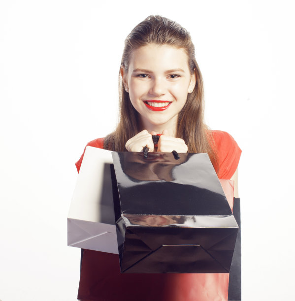 年轻漂亮的女人穿着红色的包在圣诞节出售图片下载