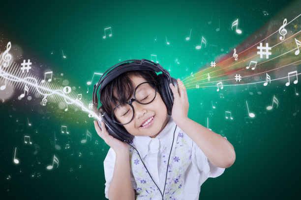 可爱的小女孩喜欢戴着耳机听音乐图片下载