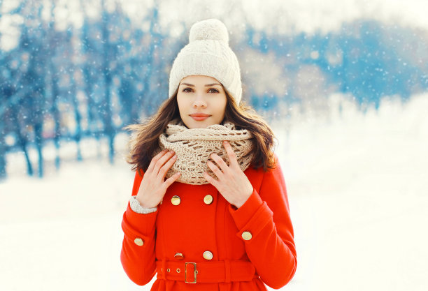 漂亮的年轻女子穿着红色外套，戴着帽子和围巾过冬图片下载