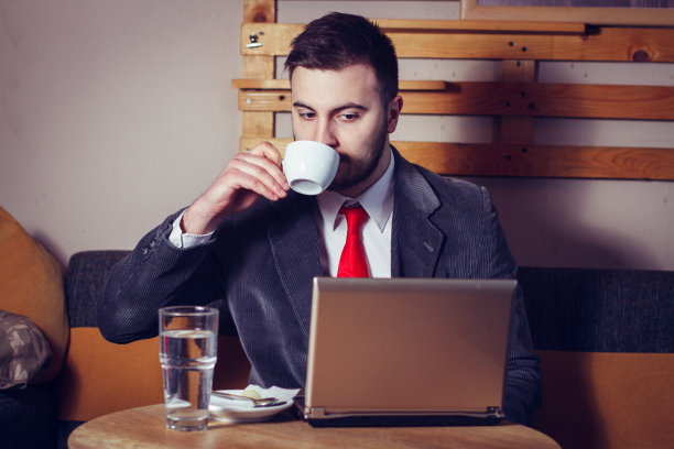 在咖啡店里使用笔记本电脑的商人图片下载