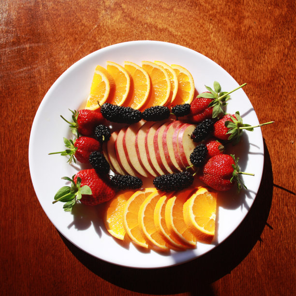 装有橘子片和苹果片的盘子。草莓、桑椹。图片下载