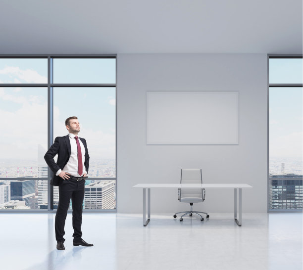 英俊的商人站在现代化的办公室里图片下载