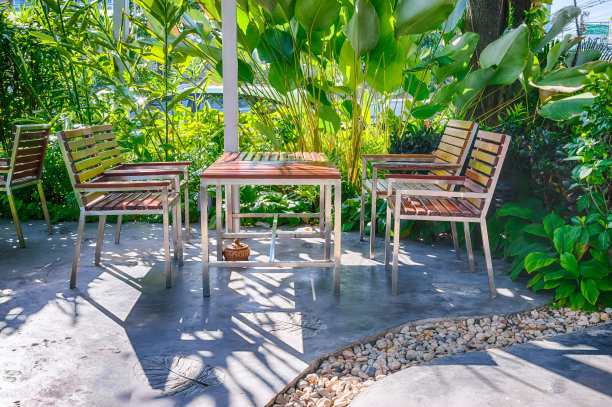 木桌设置在郁郁葱葱的花园设置图片下载