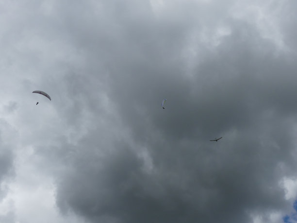 滑翔伞和悬挂式滑翔伞对抗着乌云图片下载