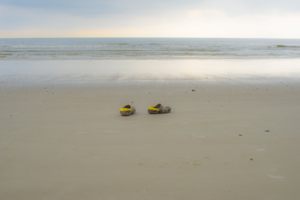 日落时分沙滩上一个男人的鞋子图片下载