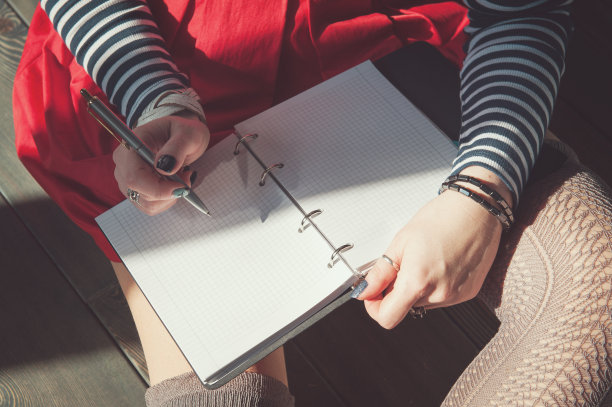 女人在笔记本上写字的温馨照片图片下载