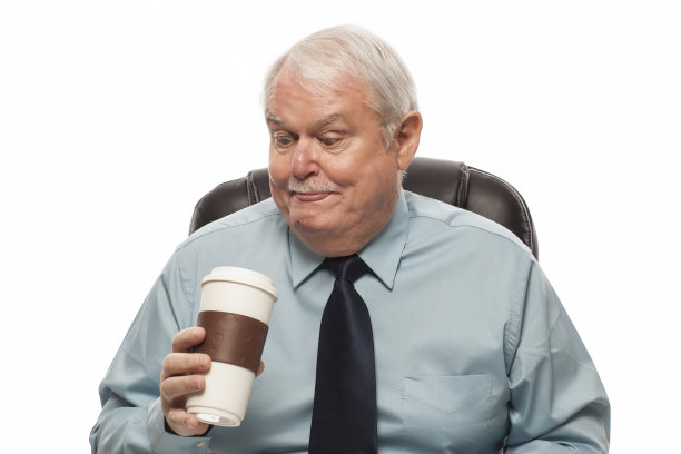 老员工低头看着他的咖啡杯。图片下载