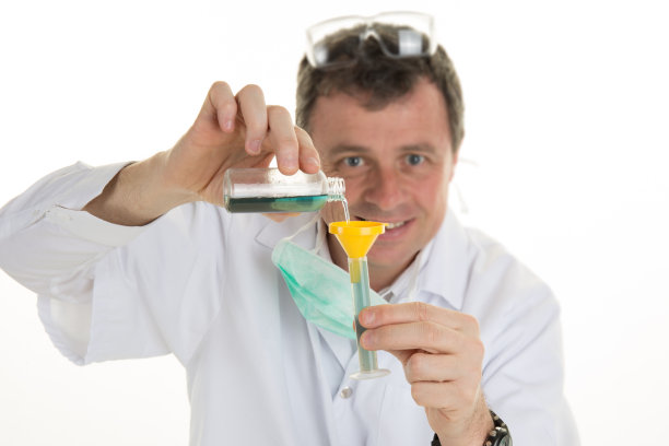 严肃的临床医生在看装有蓝色液体的烧瓶图片下载