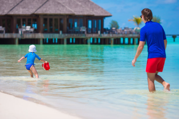 幸福的家庭在白色的热带海滩上玩图片下载