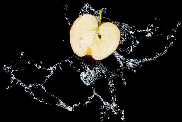 苹果片与水溅在黑色的背景图片下载