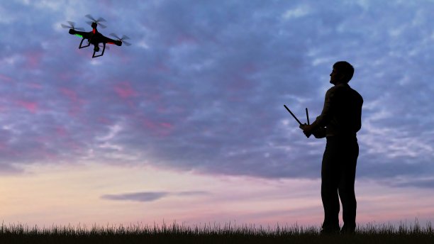 在日落时操纵无人机的人图片下载