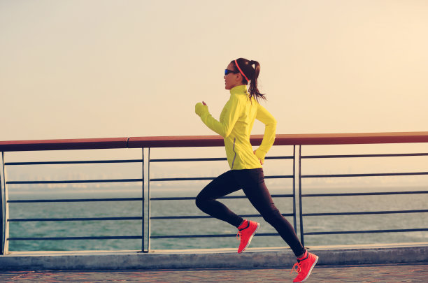 年轻的健身女运动员在海边跑步图片下载
