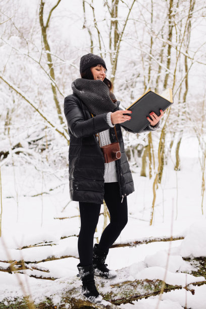 在冬天的森林里拿着书的女孩图片下载
