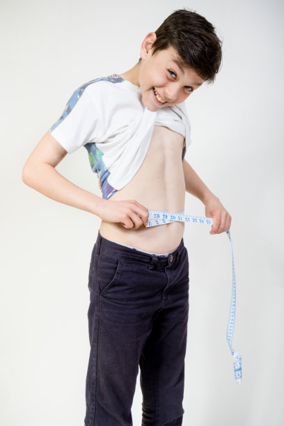 快乐的小男孩测量他的腰围图片下载