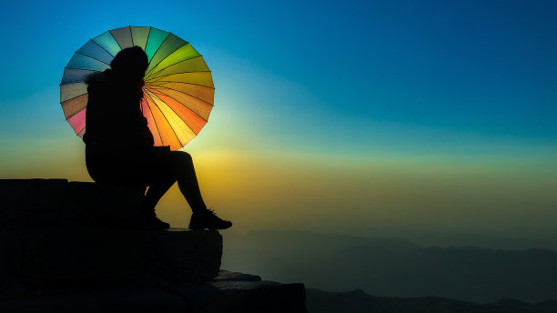 清晨，拿着伞的妇女在内姆鲁特迎接日出图片下载