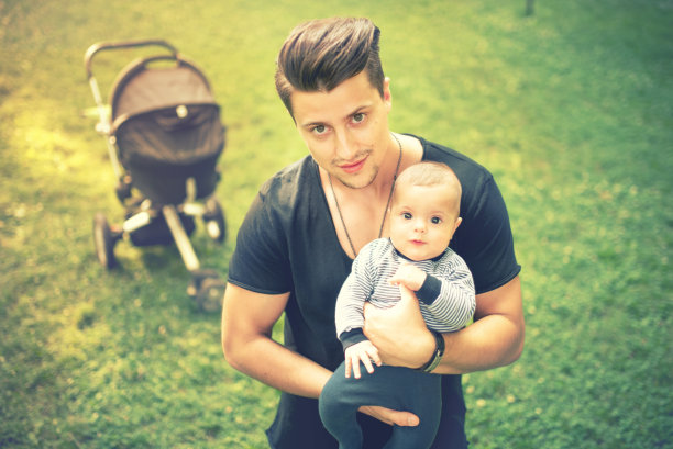 年轻的父亲抱着并亲吻刚出生的，3个月大的儿子图片下载