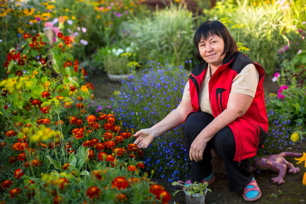 成熟的女人在她的花园里。图片下载