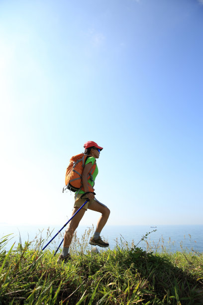 年轻女子在海边山间小径徒步旅行图片下载