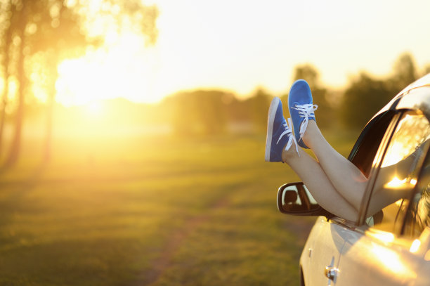 女人在车里把腿伸出窗外。图片下载