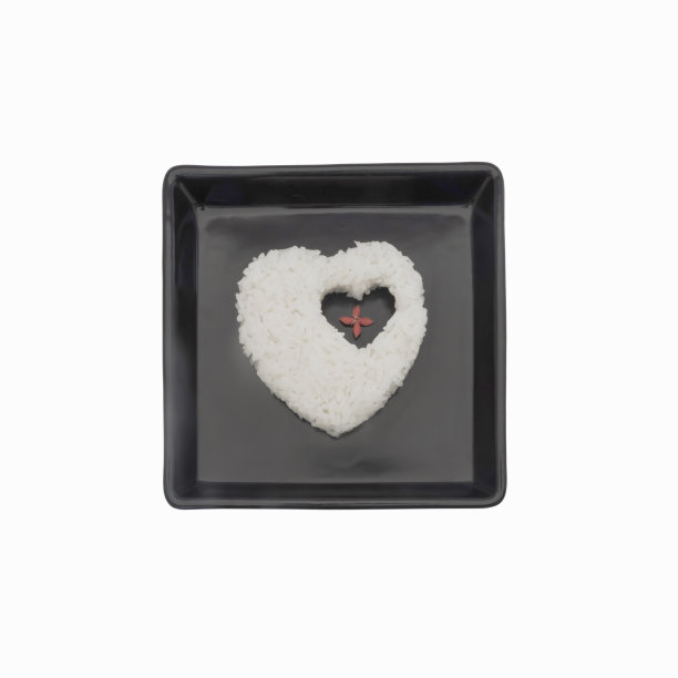茉莉花米饭心形放在黑色盘子上图片下载
