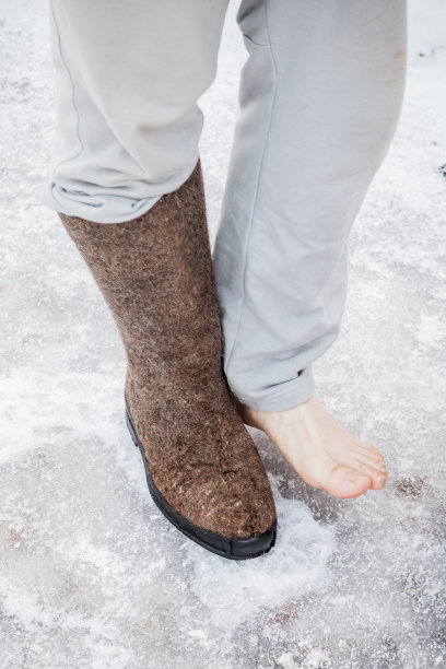 男性脚与一个传统的俄罗斯灰色毡靴图片下载
