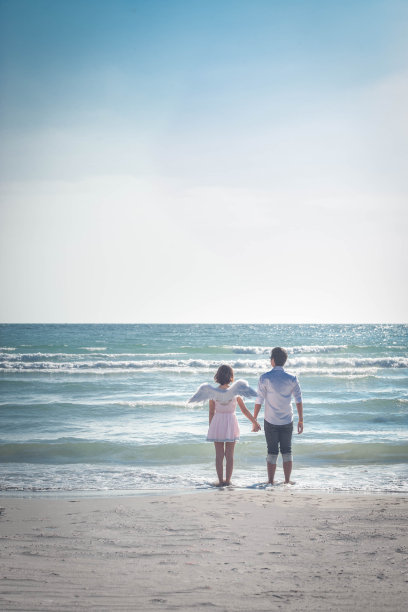 在热带海滩上牵手的情侣。图片下载