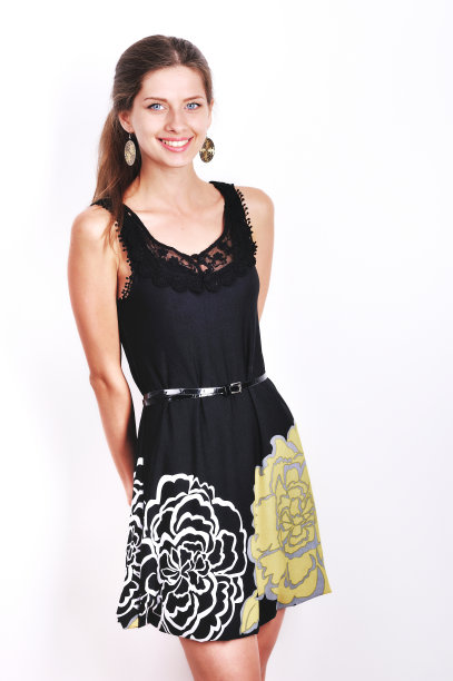 年轻女性穿着黑色连衣裙在工作室摆姿势。图片下载