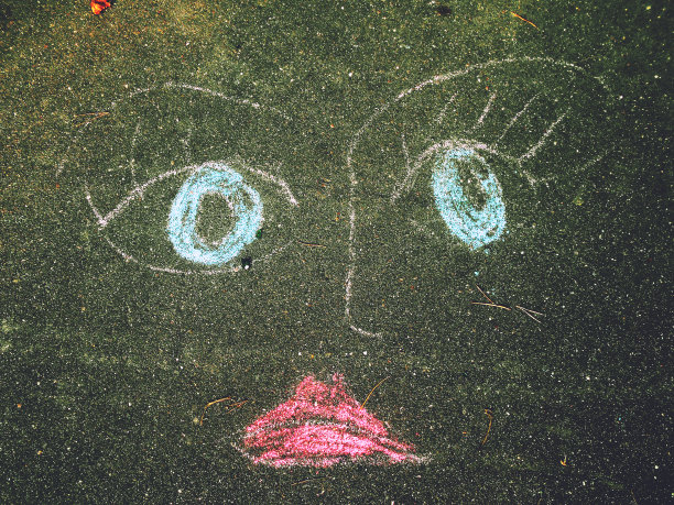 悲伤的脸画在沥青上，彩色蜡笔图片下载