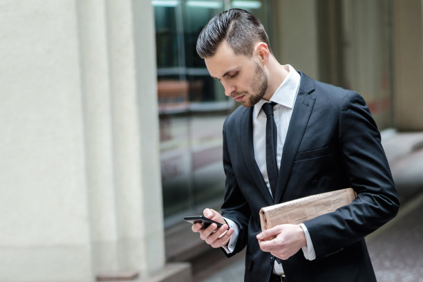 客户的电话。身着正装的年轻人站着图片下载