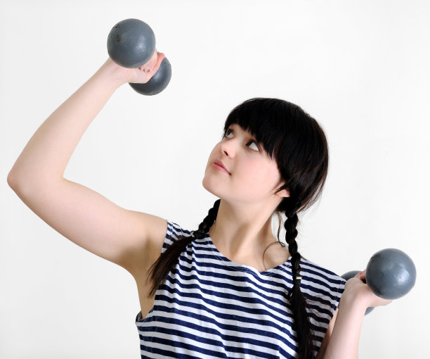 拿着两个旧哑铃的年轻女人图片下载