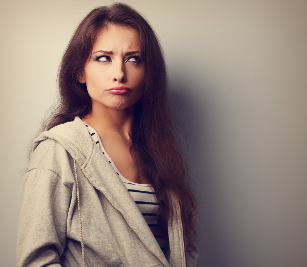 愁眉苦脸的有趣的年轻女人，思考和看起来很有趣。古董图片下载