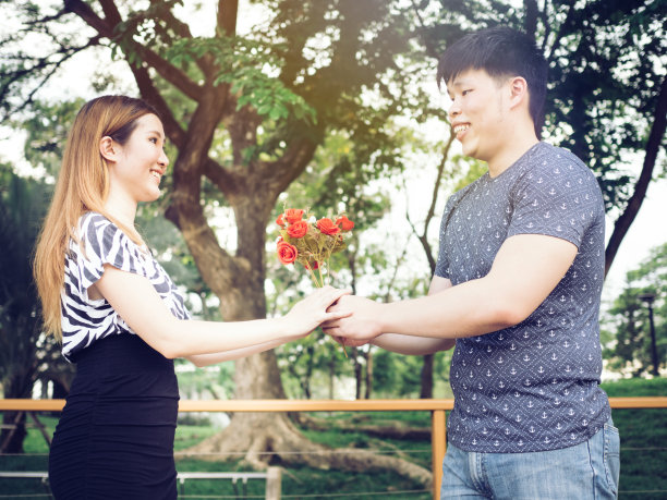 亚洲夫妇在公园里赠送一束玫瑰素材图片