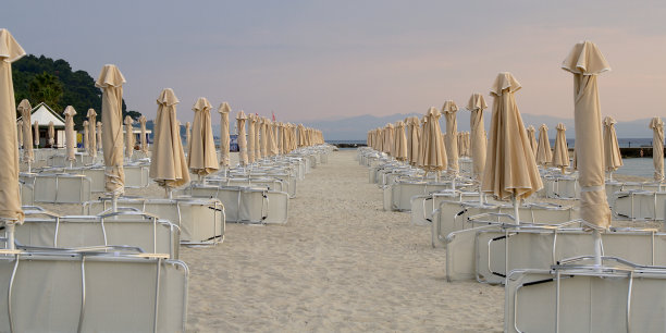 日出时的沙滩伞和日光浴床图片下载