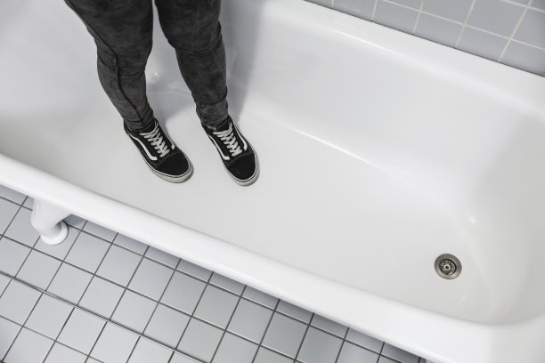 十几岁的少年在运动运动鞋站在白色浴缸图片下载