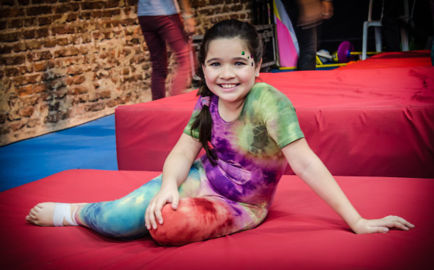 微笑的体操女孩躺在床垫上图片下载